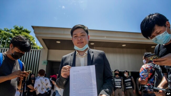 Phansuwan Nakeaw, center, stands outside the Embassy of Japan in Bangkok, Thailand, Tuesday, Aug. 25, 2020, requesting that the self-exiled in Japan, Pavin Chachavalpongpun, administrator of the Facebook group “Royalist Marketplace” be deported back to Thailand.