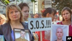 FILE - Relatives of the Ukrainian prisoners of war hold their portraits at a rally outside the German embassy in Kyiv, Ukraine, Sept. 14, 2016. 