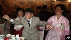 Yoo Youn-shick, 92, dari Korea Selatan, menari bersama keponakan-keponakannya dari Korea Utara dalam makan malam reuni keluarga di resor Diamond Mountain di Korea Utara (20/2). (AP/Yonhap, Lee Ji-eun)
