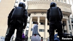 FILE - Egyptian security forces stand guard outside the court during the trial of a human rights lawyer and ex-presidential candidate in Cairo, Jan. 3, 2018. 