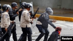 Una manifestante es capturada por la policía.