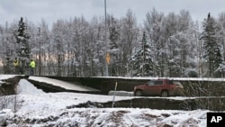 Automobil zarobljen na putu koji se urušio u Enkoridžu, na Aljasci, posle dva potresa od 7 i 5,8 stepeni Rihterove skale (Foto: AP)