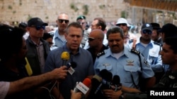 FILE - Israel's Public Security Minister Gilad Erdan, center, and police commissioner Roni Alsheich speak to members of the media at the Western Wall in Jerusalem's Old City, June 10, 2016.