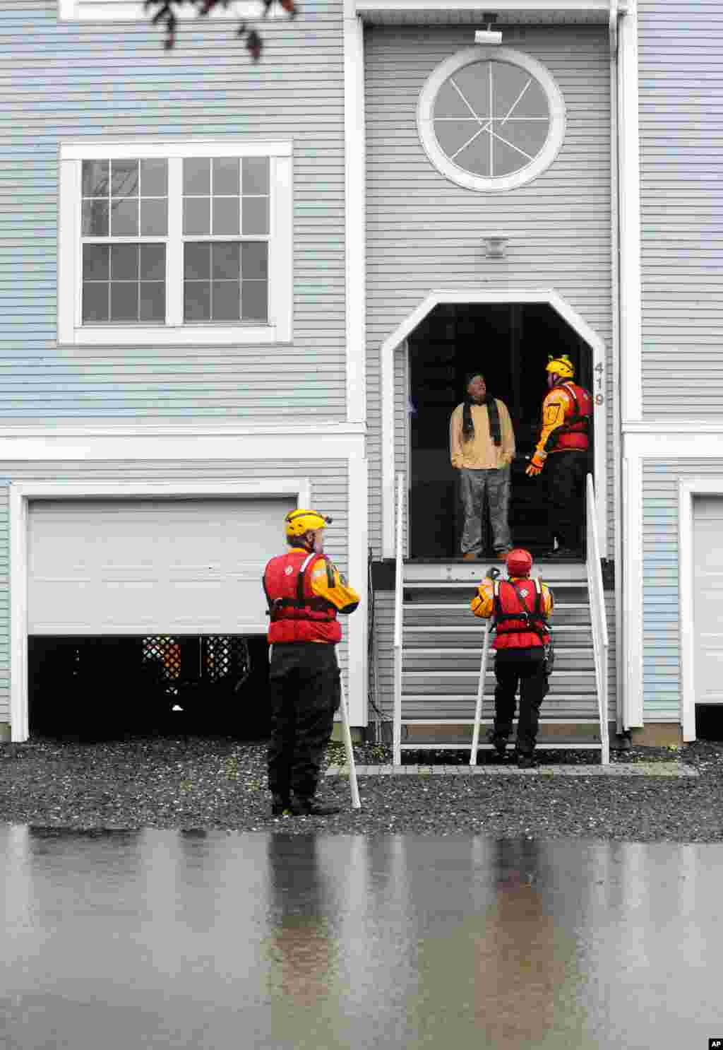 Miembros del equipo de rescate del condado de Harford en Maryland alertan a un residente para que evac&uacute;e voluntariamente su residencia despu&eacute;s del paso de Sandy. 