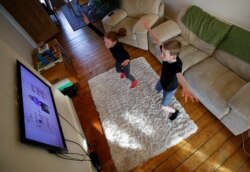 Alice dan Joseph Wilkinson tengah mengikuti kelas online di rumah mereka di Manchester, Inggris, 23 Maret 2020. (Foto: Reuters / Phil Noble)