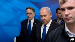 FILE - Israeli Prime Minister Benjamin Netanyahu, center, arrives with Cabinet Secretary Tzachi Braverman for a weekly cabinet meeting at the prime minister's office in Jerusalem, April 29, 2018. Israeli media said Tuesday that the meetings have been moved to a secure underground bunker in Jerusalem.