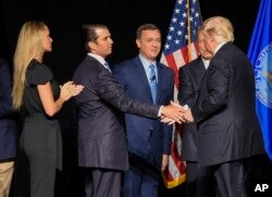 El presidente Donald Trump, felicitado por su hijo Donald Trump Jr. luego de su discurso en la Convención anual del NRA 2017 en Atlanta, Georgia.