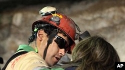 In this photo released by the Chilean government, miner Florencio Avalos, second left, hugs a relative after he was rescued from the collapsed San Jose mine near Copiapo, Chile, early Wednesday, 13 Oct. 2010