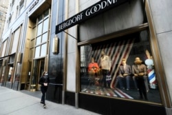 A lone woman window shops along a sparsely occupied Fifth Avenue, Wednesday, March 18, 2020 in New York. (Photo by Evan Agostini/Invision/AP)