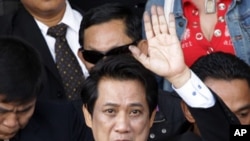 Arisman Pongruangrong, a "Red Shirt" hard core leader waves as he leaves the Department of Special Investigation office to the Attorney General office at the Department of Special Investigation in Bangkok, Thailand, December 7, 2011.