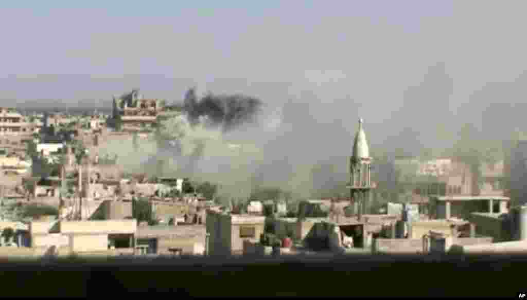 This image released by Shaam News Network purports to show explosions in the Khaldiyeh area of Homs, Syria, June 8, 2012. 