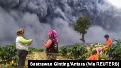 Para petani memanen kentang saat Gunung Sinabung erupsi, di Kabupaten Karo, Sumatra Utara, 10 Agustus 2020. (Foto: Sastrawan Gintin/Antara via Reuters)