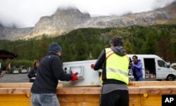 کارکنان یک رادار را در یک جعبه با هلیکوپتر به یخچال «پلان‌پنسیو» در مون بلان حمل می کنند. این رادار برای نظارت سرعت ذوب شدن یخ های این یخچال طبیعی است تا کارشناسان را از خطرات آتی برحذر دارد. ۲۵ سپتامبر ۲۰۱۹