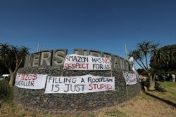 FILE - Banners are seen during a picket by the Goringhaicona Khoi Khoin Indigenous Traditional Council and protesters from the surrounding communities against the construction of the new African headquarters for U.S. retail giant Amazon, in Cape Town, Sou