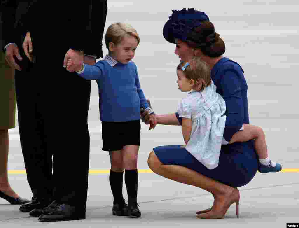 Catherine, Duchess of Cambridge, holds the hand of her son Prince George while carrying Princess Charlotte as they arrive at the Victoria International Airport for the start of their eight day royal tour to Canada in Victoria, British Columbia, Canada, Sept. 24, 2016.