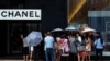 Mainland Chinese tourists wait outside a Chanel store at Hong Kong's Tsim Sha Tsui shopping district, Oct. 1, 2014, with part of it being blocked by protesters.