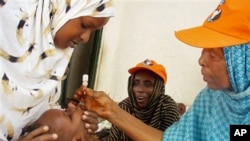 A World Health Organization official gives a dose of polio vaccine to a Somali child in Mogadishu, Sep 2006 (file photo)