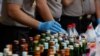 Police prepare evidence during a press conference, April 11, 2018, regarding the arrests of suspects linked to the production and sale of illegal bootleg alcohol, which claimed the lives of more than 80 people this week in Jakarta and nearby West Java province.