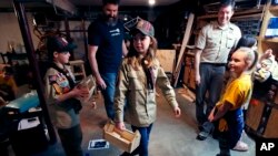 FILE - Tatum Weir, center, carries a tool box she built as her twin brother Ian, left, follows after a Cub Scout meeting in Madbury, N.H., March 1, 2018. Fifteen communities in New Hampshire are part of an "early adopter" program to allow girls to become Cub Scouts and eventually Boy Scouts. For 108 years, the Boy Scouts of America's flagship program for older boys has been known simply as the Boy Scouts. With girls soon entering the ranks, the BSA says that iconic name will change to Scouts BSA. 