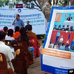 Khmer Rouge Tribunal spokesman Lars Olsen speaking to former members of the ultra-Maoist group in Anlong Veng, Cambodia at the home of Ta Mok, a former senior leader believed to have been responsible for many of the regime's worst atrocities. The poster o