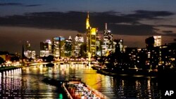 A cargo ship is seen on the river Main with the bank buildings in background in Frankfurt, Germany, late Wednesday, April 17, 2019.