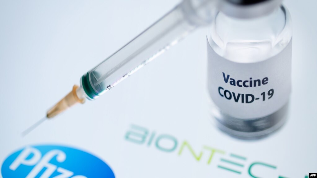 (FILES) In this file photo taken on November 23, 2020 This illustration picture taken on November 23, 2020 shows a bottle reading "Vaccine Covid-19" and a syringe next to the Pfizer and Biontech logo. - Britain on December 2, 2020 became the first country