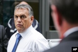 Hungarian Prime Minister Viktor Orban, right, arrives for a European Peoples Party, EPP meeting, ahead of an emergency EU heads of state summit on migration, in Brussels on Sept. 23, 2015.