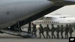 In this image made from video, marines board a transport plane in Manila, Philippines, June 1, 2017. A marine battalion left an air force base in Manila on deployment to the southern city of Marawi where ongoing violence has killed scores of people. 