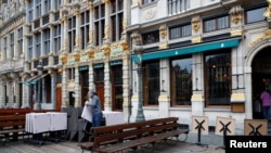 Nhân viên sắp xếp bàn ghế ngoài trời ở một quán bar ở thủ đô Brussels sau khi Bỉ dỡ phong tỏa