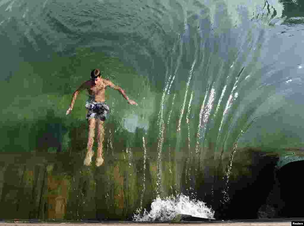 ایک لڑکا پانی میں چھلانگ لگا رہا ہے۔