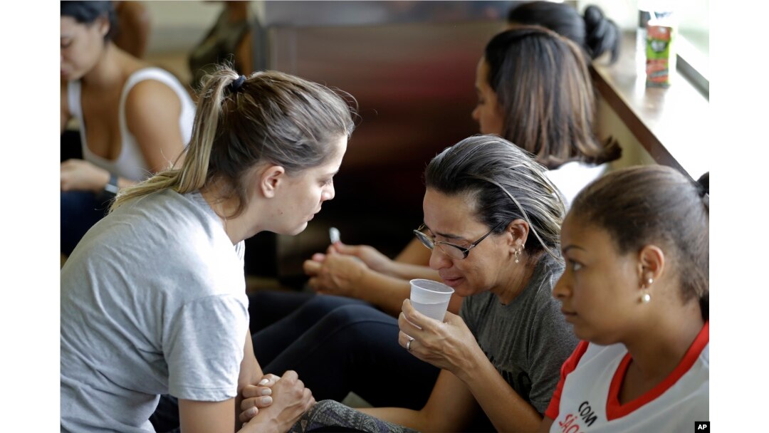A woman is comforted by a volunteer as she waits for informations about missing relatives, after a dam collapsed in Brumadinho, Brazil, Jan. 26, 2019. The Brazilian mining company Vale SA CEO Fabio Schvartsman said he did not know what caused the collapse.