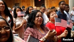 FILE - New citizens stand during a U.S. Citizenship and Immigration Services (USCIS) naturalization ceremony at the New York Public Library in Manhattan, New York, July 3, 2018. (REUTERS/Shannon Stapleton)