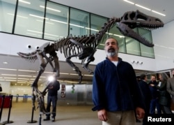 Argentine paleontologist Sebastian Apesteguia poses next to a replica of an unusual new theropod from the upper Cretaceous discovered in Argentina's Patagonia, in Buenos Aires, Argentina, July 13, 2016.