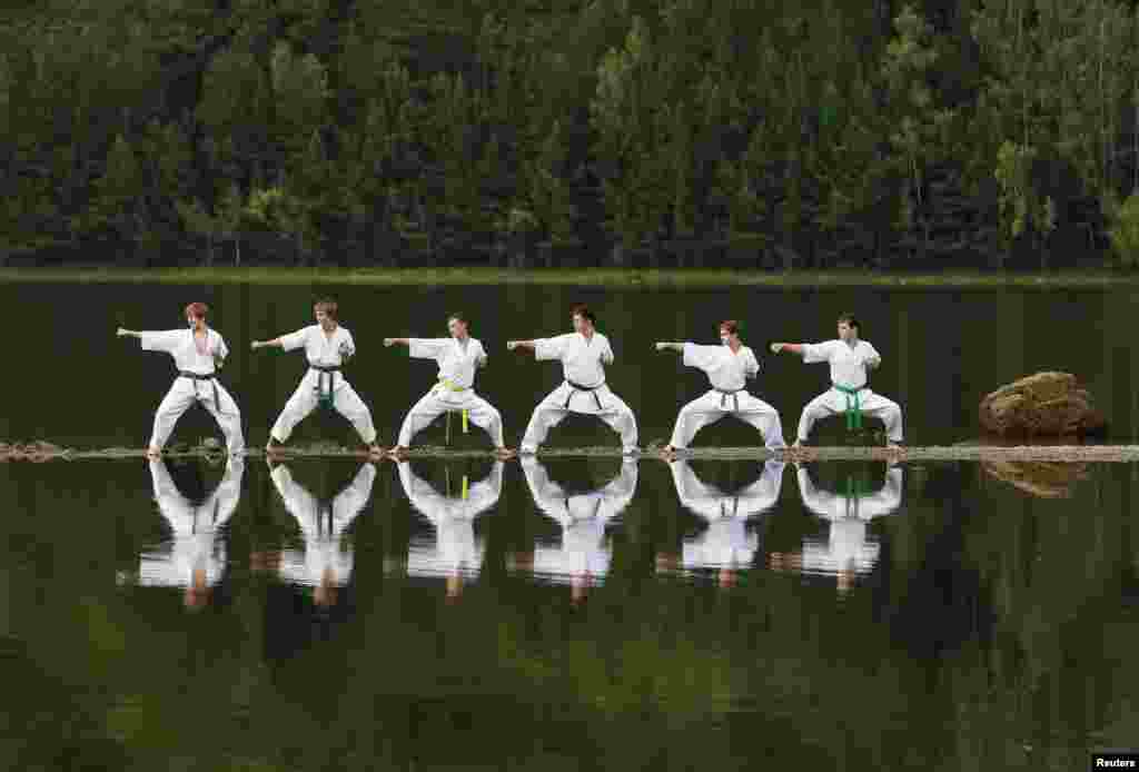 Young members of a local Kyokushin Karate federation perform during an exercise session at a summer training camp in Taiga district on a bank of the Yenisei River near the town of Divnogorsk, outside Krasnoyarsk, Siberia.