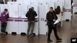 Voters fill in their ballots at a polling station at Town Hall in Sydney on July 2, 2016. 