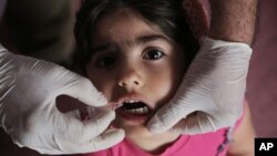 Bé Rose Mohammed, 4 tuổi, uống vaccine ngừa bại liệt ở Baghdad, Iraq.