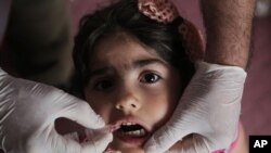 FILE - Health workers are trying to vaccinate Iraqi youngsters against polio. Rose Mohammed, 4, receives a vaccine at a Baghdad kindergarten April 10, 2014. 