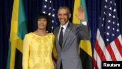U.S. President Barack Obama stands for a photograph with Jamaica's Prime Minister Portia Simpson Miller upon his arrival at Jamaica House in Kingston, April 9, 2015. 