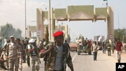 Anti-Gaddafi fighters stand guard after they took over El-Khamseen gate, the eastern gate of Sirte, Libya, September 24, 2011.