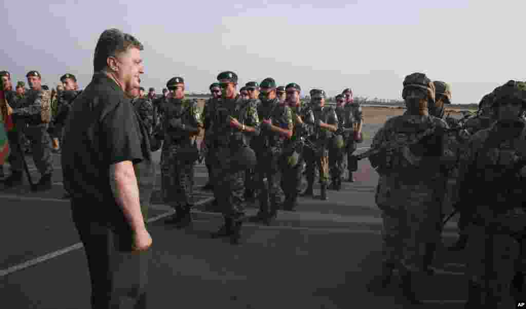 Ukrainian President Petro Poroshenko, left, inspects military personnel during his visit to the southern coastal town of Mariupol, Ukraine, Sept. 8, 2014.