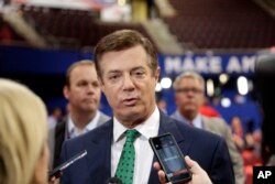 FILE - Trump Campaign Chairman Paul Manafort talks to reporters on the floor of the Republican National Convention at Quicken Loans Arena, July 17, 2016, in Cleveland.