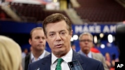 FILE- Paul Manafort talks to reporters on the floor of the Republican National Convention, July 17, 2016, in Cleveland.