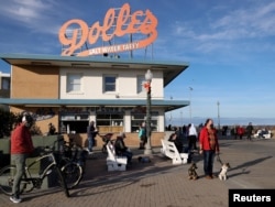 FILE - People try to keep a social distance due to the coronavirus disease (COVID-19) pandemic as they gather on the boardwalk in Rehoboth Beach, Delaware, U.S. January 2, 2021. (REUTERS/Jonathan Ernst)
