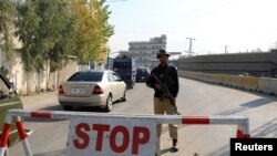 FILE - A policeman stands guard on a road in Mingora, in Swat Valley, Pakistan, Dec. 4, 2016. Saturday, a suicide bombing targeted army officials in a part of the scenic valley where members of the military conduct sports activities.