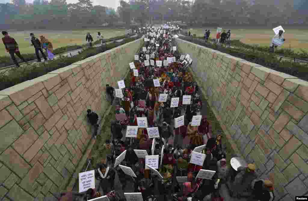 Women carrying placards enter Raj Ghat to attend a prayer ceremony for a rape victim after a rally organized by Delhi Chief Minister Sheila Dikshit (unseen), New Delhi, India, January 2, 2013. 