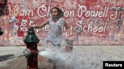 Una niña se refresca en un hidrante abierto en el vecindario de Washington Heights, en Manhattan, Nueva York, el 19 de julio de 2019. REUTERS/Mike Segar.