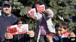 Sornic, left, and Gabriel hold gift cards received by their parents, Aaron and Sheyla Crawford, outside their Apple Valley, Minn., home on Saturday, Nov. 21, 2020. (AP Photo/Jim Mone)