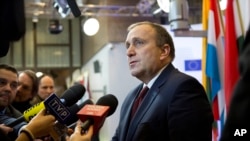 FILE - Polish Foreign Minister Grzegorz Schetyna speaks with the media prior to a meeting of EU foreign ministers at the EU Council building in Brussels.