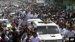 Burma's pro-democracy leader Aung San Suu Kyi waves her hand to supporters on her arrival in Dawei, about 615 km (380 miles) south of Rangoon, January 29, 2012.