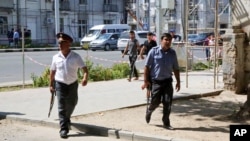 Police officers secure an area in the capital of Tajikistan, Dushanbe, where several Interior Ministry special forces officers and a traffic policeman were reportedly shot dead, Sept. 4, 2015. 